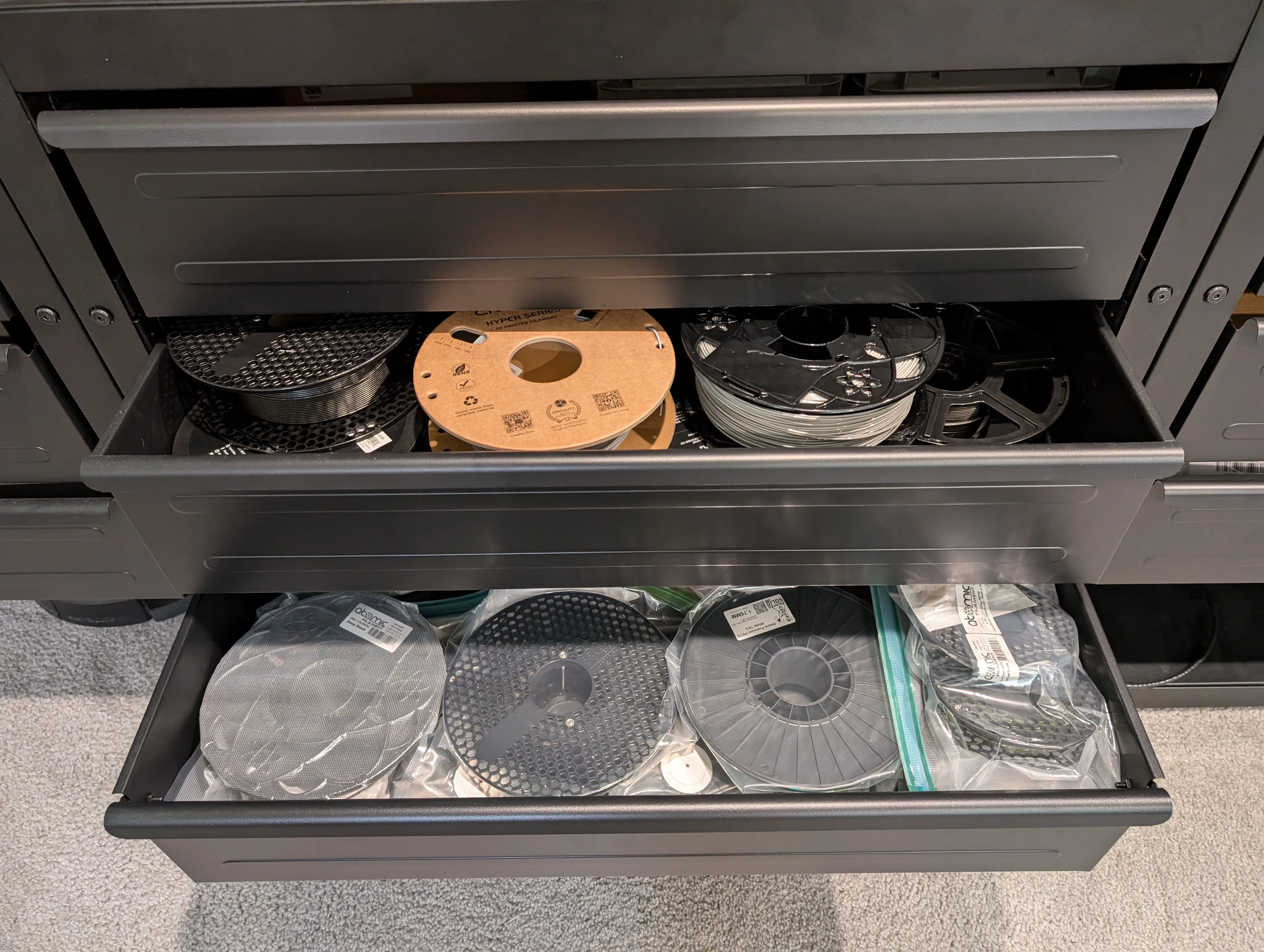 3 Ikea drawers, with the bottom two open, with 13 visible spools on top of each other